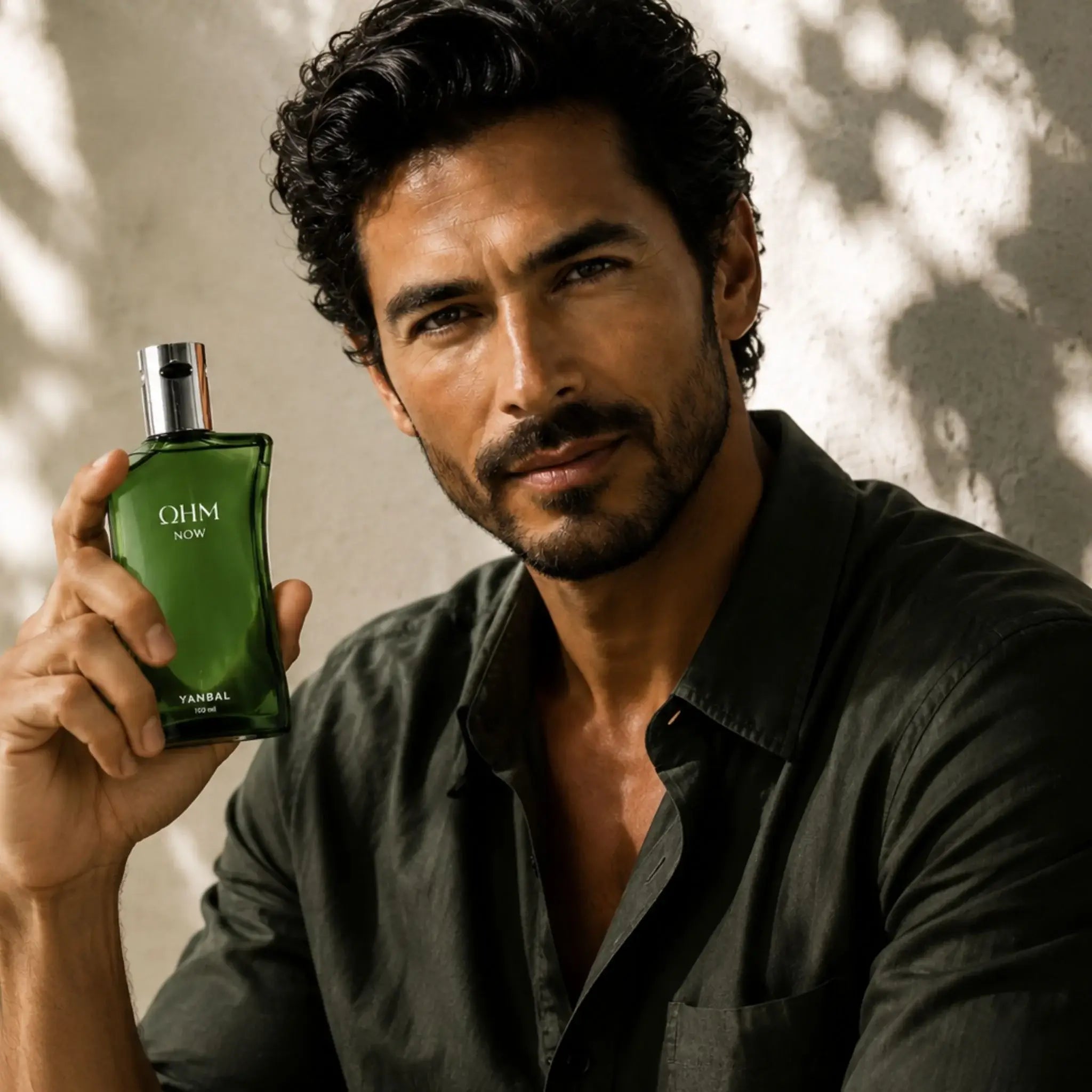 Hombre sosteniendo perfume OHM NOW de Yanbal, fragancia masculina aromática y elegante de 100 ml.